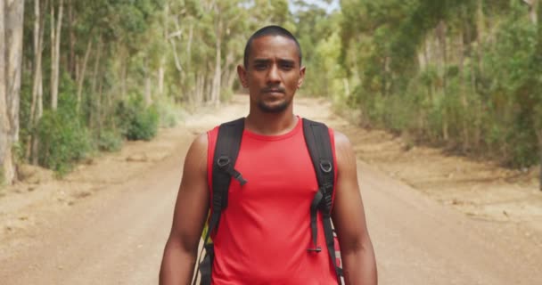 身强体壮 身弱力壮的混血男子的画像 享受登山之旅 在森林里散步 在阳光明媚的日子看着相机 慢动作 — 图库视频影像