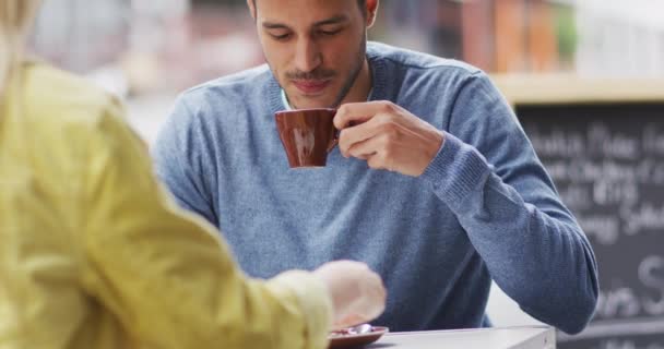 在一个阳光明媚的城市里 这对白种人夫妇坐在咖啡台上的一张桌子旁 一边喝咖啡一边互动 — 图库视频影像