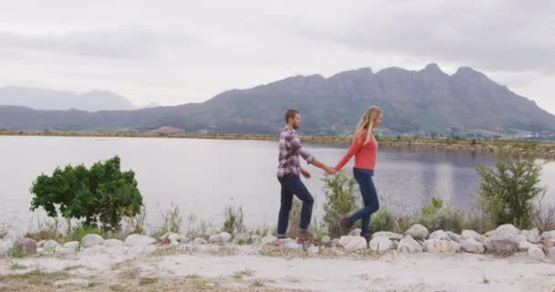 白种人夫妇在登山旅行中度过了一段愉快的时光 他们在湖边散步 手牵手 动作缓慢 — 图库视频影像