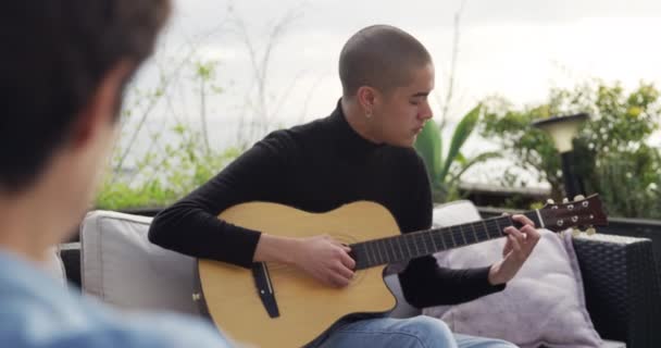 在阴天 一个高加索人在屋顶的阳台上玩耍 在他的朋友面前弹吉他 动作缓慢 — 图库视频影像