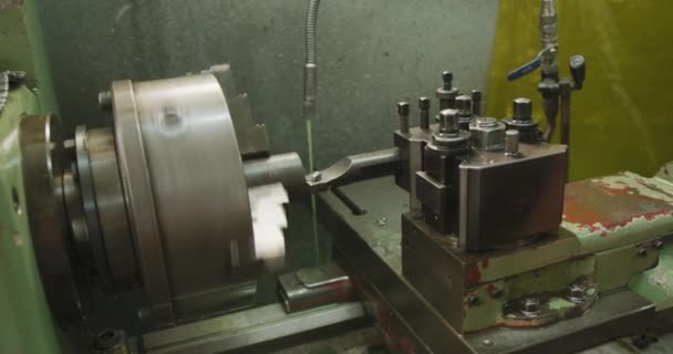 油圧機器を製造する工場でのワークショップで機械の作品の詳細を閉じる 液体の冷却ジェットで回す スローモーションで — ストック動画