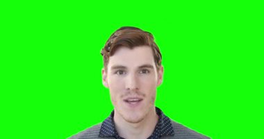 Kahverengi saçlı heyecanlı bir beyaz adamın portresi, şaşırmış ve mutlu, el kol hareketi yapan, gülümseyen ve yeşil arka plandaki kameraya bakan.