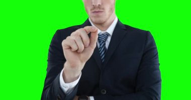 Beyaz gömlekli ve takım elbiseli, yakışıklı beyaz bir adamın orta kesimi. Kolunu kaldırıp önüne doğru uzatıyor ve yeşil arka plandaki sanal interaktif ekrana dokunuyor..