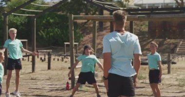 Güneşli bir günde, Acemi Birliğindeki beyaz bir erkek koç, yeşil t-shirtler giyerek zıplayan ve ağır çekimde