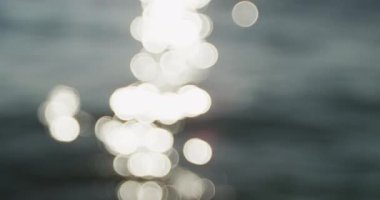 Güneş ışığının odak noktasından suya yansıyan dalgalı beyaz noktalar gibi yavaş çekimde.