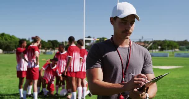 Vista Frontal Treinador Rugby Masculino Caucasiano Campo Jogo Segurando Uma — Vídeo de Stock