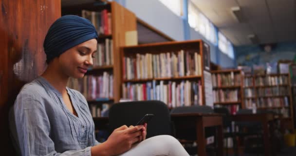 Šťastná Asijská Studentka Modrém Hidžábu Studující Knihovně Sedící Používající Smartphone — Stock video