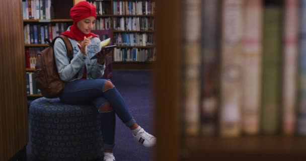 Uma Estudante Asiática Vestindo Hijab Vermelho Estudando Uma Biblioteca Sentada — Vídeo de Stock