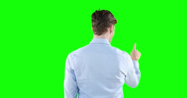 一个英俊的白种人 棕色头发 身穿浅蓝色衬衫 手臂高举 手伸向前方 在绿色背景下触摸虚拟互动屏幕 — 图库视频影像