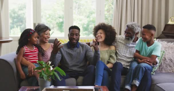 代代相传的混血种族家庭 在科罗纳韦病毒肆虐期间 慢慢地享受在家里的时光 坐在沙发上 与人交流 面带微笑 保持社交距离 自我隔离 — 图库视频影像