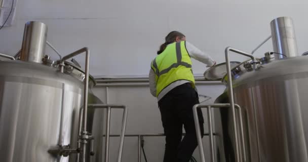 Hombre Caucásico Trabajando Una Microcervecería Llevando Chaleco Alta Visibilidad Inspeccionando — Vídeo de stock