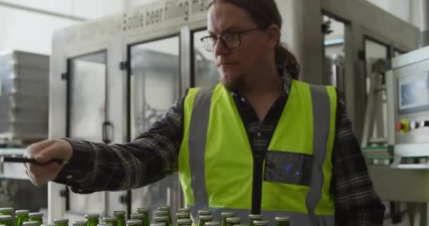 Белый Мужчина Бронежилете Работает Пивоварне Считает Бутылки Пива Приготовленные Доставке — стоковое видео