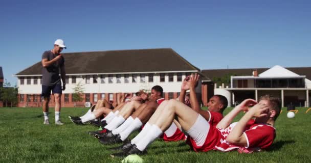 민족을 선수들 빨간색 스트립을 경기장에서 훈련하고 앉아서 일어나는 훈련하고 동작으로 — 비디오