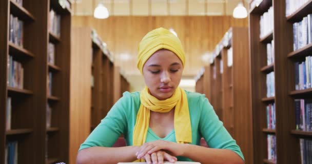 Egy Ázsiai Diáklány Sárga Hidzsábot Visel Egy Könyvtárban Tanul Egy — Stock videók