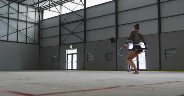 Genç Melez Kadın Jimnastikçinin Spor Salonunda Performans Sergilemesi Bir Çemberle — Stok video