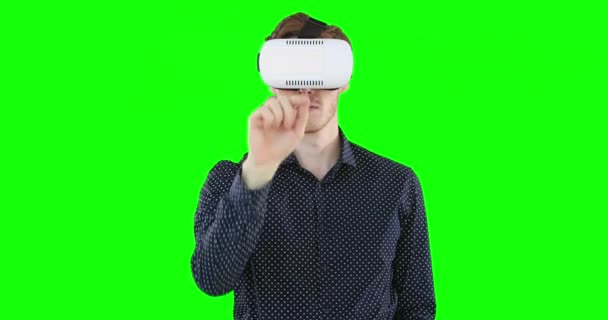 黒のシャツを着て 茶色の髪を持つフォーカス白人男性 緑の画面上のVrヘッドセットを使用している間笑顔とジェスチャー — ストック動画