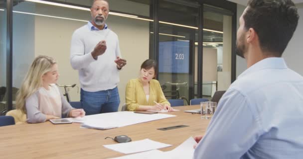 在非正式的现代办公室工作的非裔美国男性企业家的前瞻 他们站在一个会议上向各种各样的同事致辞 — 图库视频影像