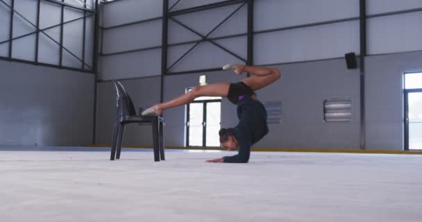 Widok Boku Nastoletniej Mieszanej Rasy Gimnastyczki Ćwiczącej Siłowni Rozciągającej Się — Wideo stockowe