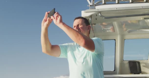 Vista Lateral Homem Caucasiano Aproveitando Seu Tempo Barco Segurando Smartphone — Vídeo de Stock