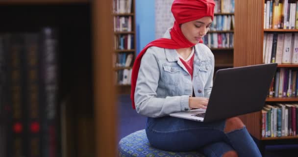 Asijská Studentka Červeném Hidžábu Studující Knihovně Sedí Používá Notebook Sobě — Stock video