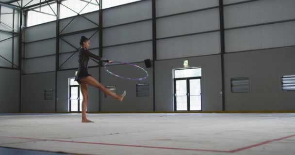 Genç Melez Kadın Jimnastikçinin Spor Salonunda Performans Sergilemesi Bacaklarında Dönen — Stok video