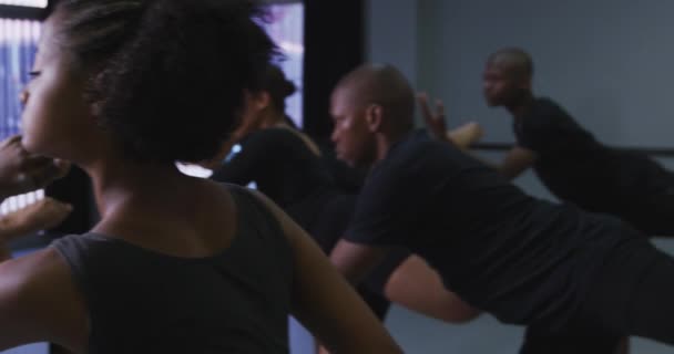 在明亮的演播室里 一群身穿黑色服装的男女现代舞蹈家在舞蹈课上练习舞蹈 摆出姿势 慢动作地保持着舞姿 — 图库视频影像