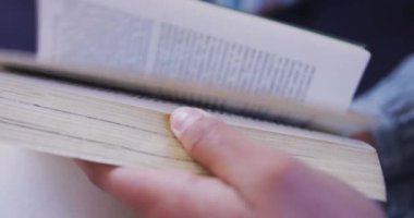 Kütüphanede okuyan, bir kitabın sayfalarını yavaş çekimde karıştıran kız öğrencilerin ellerini kapatın.