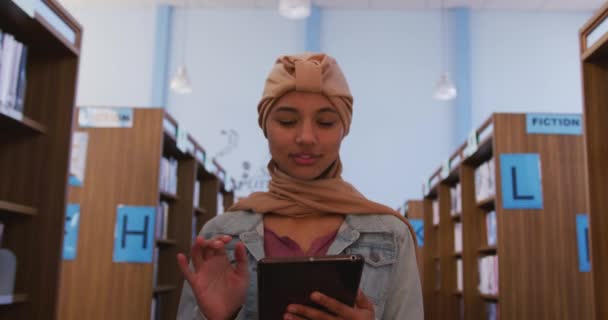 Szczęśliwa Azjatycka Studentka Beżowym Hidżabie Studiująca Bibliotece Chodząca Między Regałami — Wideo stockowe