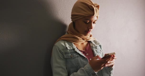 Asian Female Student Wearing Beige Hijab Leaning Wall Using Smartphone — Vídeo de stock