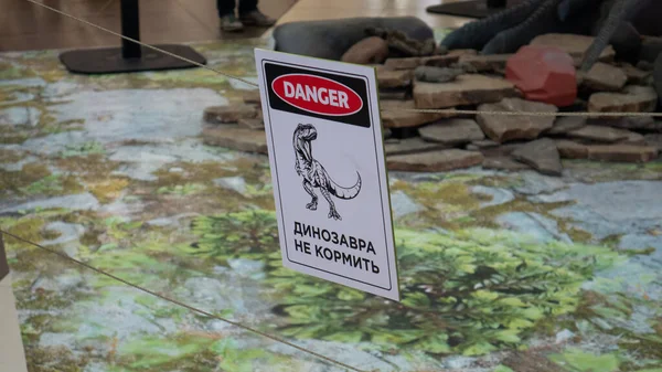 En skylt med en dinosau riskområde, inte komma in. — Stockfoto