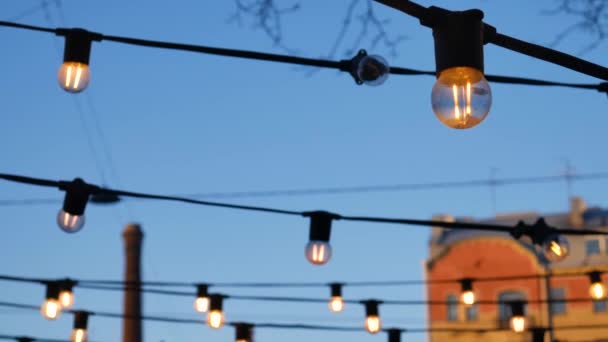 Bombillas en el fondo de los cables y el cielo azul . — Vídeos de Stock