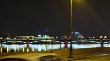 Parlak kırmızı ışıklarla süslenmiş güzel bir köprü. Gece şehrinde bir nehir ve bir köprü. St. Petersburg 'daki Palace Köprüsü, parlak kırmızı ile süslenmiş..