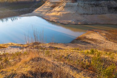 Küçük kozalaklı ağaçlı kum dağları. Dağların ortasındaki göl. Güzel doğal manzara.