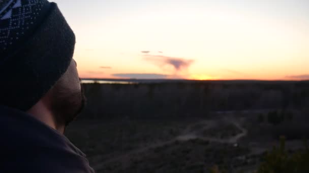 Un hombre mira hacia el horizonte . — Vídeos de Stock