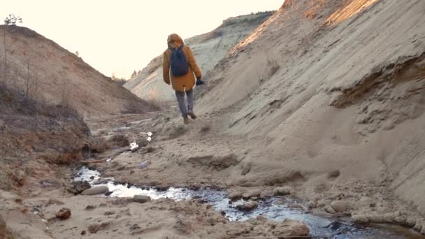 Un fotografo cammina accanto a un flusso veloce . — Video Stock