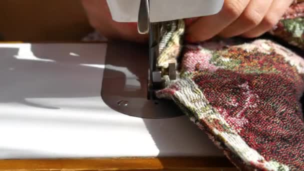 Una mujer cose tela en una máquina de coser . — Vídeo de stock