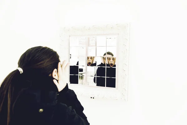 Woman looking in the mirror — Stock Photo, Image