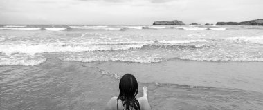 Kadın kumsalda yatıyor.