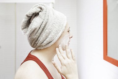 Krem yüz veren kadın