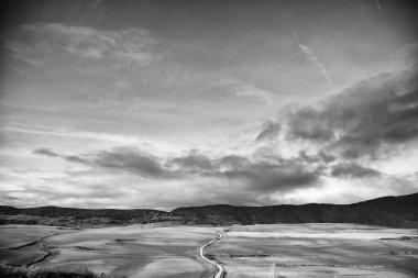 Dağları, mavi gökyüzünü, manzarası ve doğası olan kırsalda bir yol.
