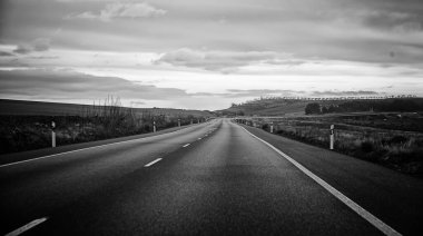 Dağları, mavi gökyüzünü, manzarası ve doğası olan kırsalda bir yol.