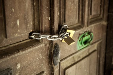 Eski terk edilmiş ahşap kapı, güvenlik detayları ve harabe.