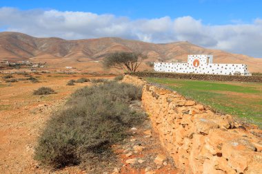 Volkanik dağ manzarası ve geleneksel Kanarya tarzı Antigua Köyü, Fuerteventura, Canary Islands, İspanya için arka planda kapı kemer