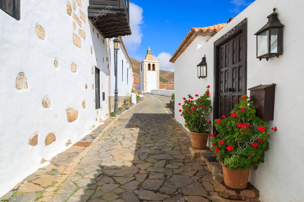 Narrow street in Betancuria village with Santa Maria church tower in background, Fuerteventura, Canary Islands, Spain