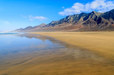 Fuerteventura, Kanarya Adaları, İspanya'nın gözlerden uzak bölümünde Cofete plajda ıslak kum dağlarda yansıması
