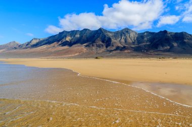 Fuerteventura, Kanarya Adaları, İspanya'nın gözlerden uzak bölümünde Cofete plajda ıslak kum dağlarda yansıması