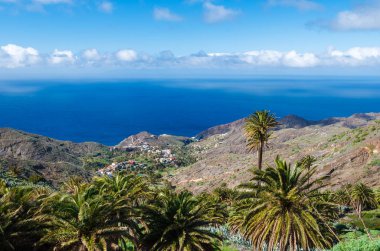 Palmiye ağacı Vadisi beyaz bulutlar mavi gökyüzü sahil deniz görünümü dağlar, Alojera, La Gomera, Kanarya Adaları