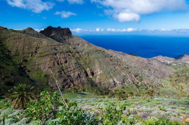 Sahil dağ Vadisi ocean view beyaz bulutlar güneşli bir gün, La Gomera, Kanarya Adaları