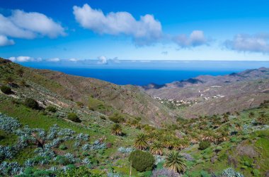 Sahil dağ Vadisi ocean view beyaz bulutlar güneşli bir gün, La Gomera, Kanarya Adaları