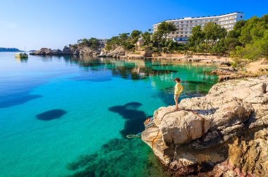 Genç kadın turist kayada Cala Fornells defne, Mayorka Adası